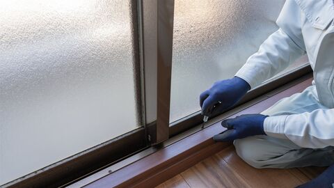 サッシ窓の下の部分を調整する作業員の手元（イメージ）
