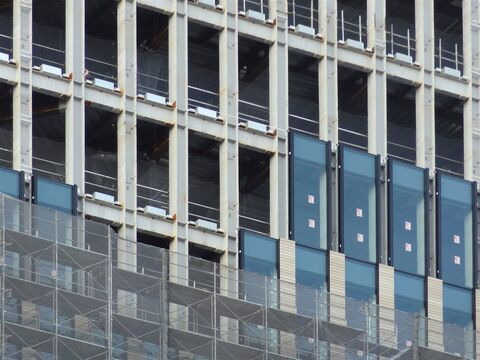 外壁のガラスの取り付けが進むビル(イメージ)