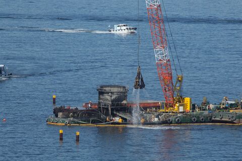 海の上でクレーン船がバケットで土砂をすくう作業(イメージ)