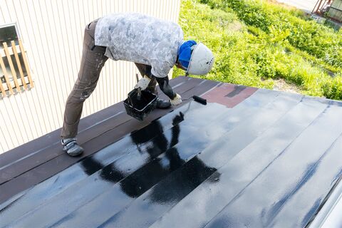 屋根のトタンを塗る職人（イメージ）